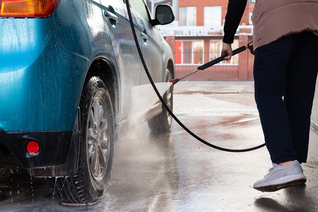 Mobile fleet washing service in Ocean County NJ — Bud's Suds pressure washing a vehicle's rear wheel and tire on-site